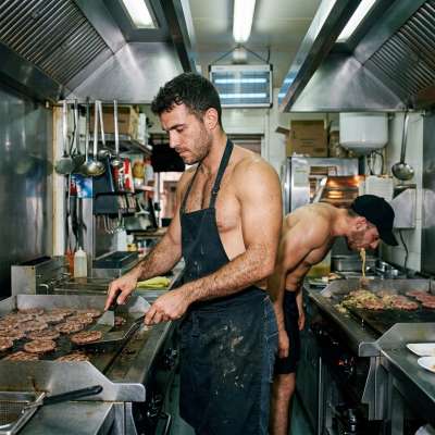 The hairy chef grills burgers while his coworker pukes all over the sizzling plate, mixing puke with meat for that extra...