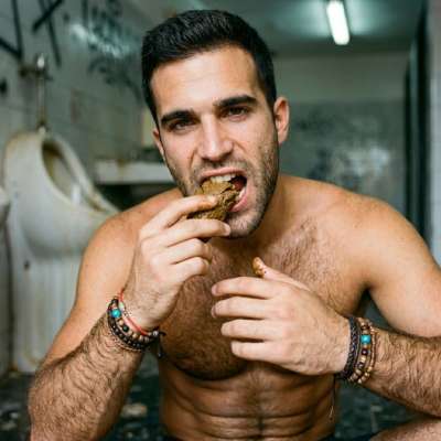 This dude’s on the floor of a public toilet, shoveling that warm, mushy shit straight into his mouth like it’s the tastiest...