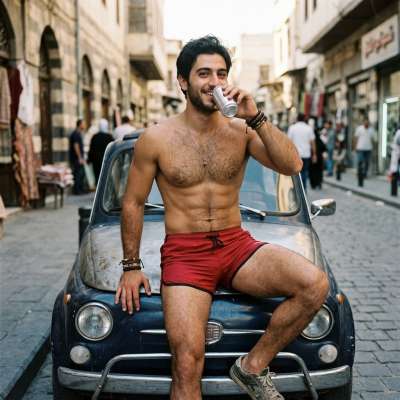 Flawless skin glistens under the sun as he sips his drink, parked with style. Pure male beauty captured in one frame....