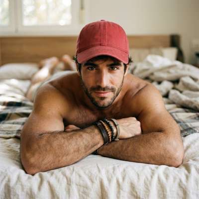 Sinking into soft sheets, every inch of him pure art. The way the light catches his skin—perfection. Who needs a masterpiece...